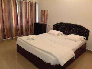 a bedroom with a large bed with a black headboard at Green Imperial in Port Blair