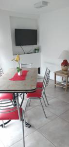 Departamentos Paradise في ريو غراندي: غرفة طعام مع طاولة مع كراسي وتلفزيون