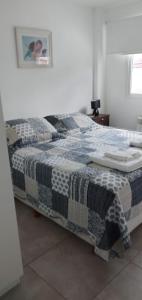 a bedroom with a bed with a black and white quilt at Departamentos Paradise in Río Grande