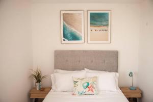 ein Schlafzimmer mit einem Bett mit zwei Bildern an der Wand in der Unterkunft Duplex Familiar Apartment Aqua in Guatapé
