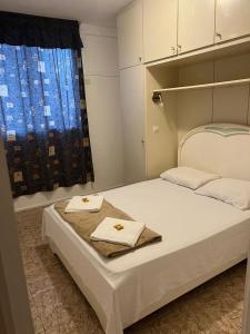 a bedroom with a white bed with two towels on it at Apartamento Temporada Barra da Tijuca in Rio de Janeiro