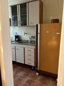 Apartamento Temporada Barra da Tijuca في ريو دي جانيرو: مطبخ مع ثلاجة حديد مقاول للصدأ وخزانة
