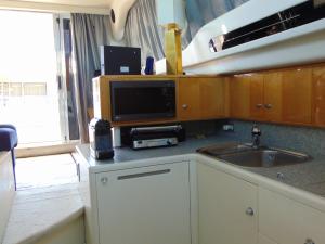 uma cozinha com um lavatório e uma televisão num balcão em Payva & Branco Boats Iate privado em Cascais em Cascais