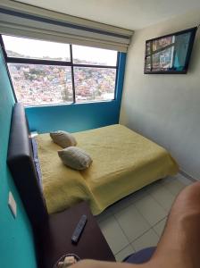 グアナファトにあるLa Lotería Panoramic House & Rooftop by Lunianのベッドと窓が備わる小さな客室です。