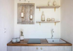 a kitchen with a counter with a sink and shelves at B&B Villa Vittoria in Giardini Naxos