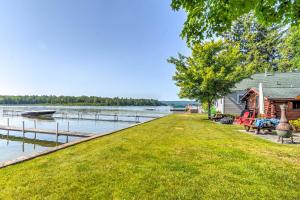 une maison sur la rive d'un lac avec un quai dans l'établissement Charming Tiny Cottage with Boat Dock on Crooked Lake, 