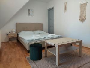 バラトンフレドにあるLudika Vendégházの小さなベッドルーム(ベッド1台、テーブル付)
