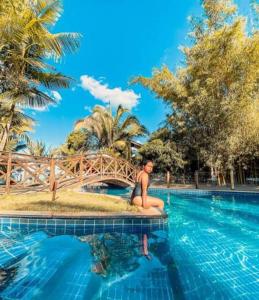 a woman sitting on the edge of a swimming pool at Sítio do Bosco Park in Tianguá