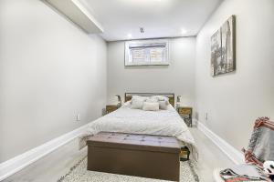 una camera con un letto in una stanza con pareti bianche di Charming and Luxurious 2BR+1Bath Guest Suite a Toronto