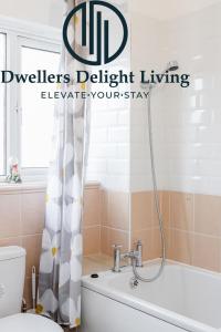 a bathroom with a toilet and a bath tub at Dwellers Delight Living Ltd Serviced Accommodation Charming 3 Bedroom Flat, Chafford Hundred, Grays with Free Parking & Wifi in West Thurrock