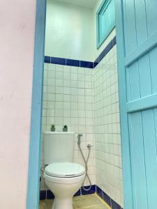 a toilet in a bathroom with a blue door at Maria Flor Pousada in Taíba