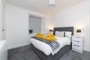 a bedroom with a bed with yellow towels on it at Central City Stay - 1 Bed Apartment in Aberdeen in Aberdeen