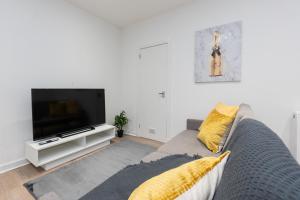een woonkamer met een bank en een flatscreen-tv bij Central City Stay - 1 Bed Apartment in Aberdeen in Aberdeen