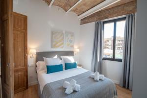 a bedroom with a bed with two towels on it at Feelathome Stadium Apartments in Hospitalet de Llobregat