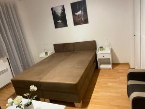 uma grande cama castanha num quarto branco em Studio 101 Fatrapark 1 Ružomberok em Ruzomberok