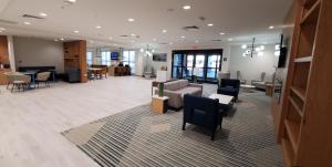 a lobby with a couch and tables and chairs at Comfort Inn & Suites Panama City Beach - Pier Park Area in Panama City Beach