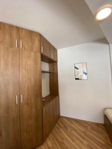 Angela Apartment في مافروفو: غرفة نوم بها دواليب خشبية وجدار أبيض