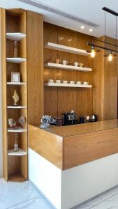 a kitchen with wooden walls and shelves with dishes at White House Apartments in Khamis Mushayt