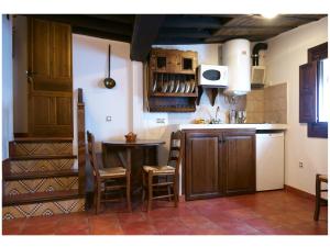 cocina con encimera, mesa y sillas en Apartamentos Rurales Víctor Chamorro del Arco, en Hervás
