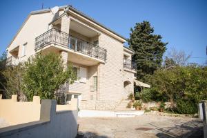 a large white brick house with a balcony at Villa Claudia Lemon Appartment in Premantura