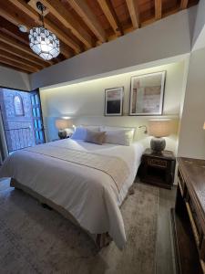 - une chambre avec un grand lit blanc et une fenêtre dans l'établissement Hotel Boutique Rincón de Luna, à San Juan del Río