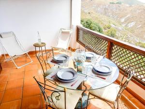 un tavolo e sedie su un balcone con vista di Apartamento en el corazon de las Alpujarras a Carataunas