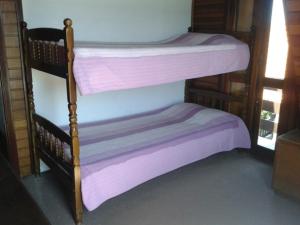 2 literas en una habitación con sábanas moradas en Chalé Lady, en Campos do Jordão