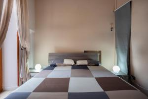 ナポリにあるSpaccaNapoli Homeのチェッカーフロアのベッドルーム1室(大型ベッド1台付)