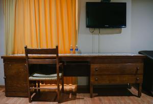 a wooden desk with a television and a chair at Hotel Casa Santa Lucia in Zacatecas