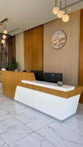 a lobby with a reception desk and a clock on the wall at White House Apartments in Khamis Mushayt