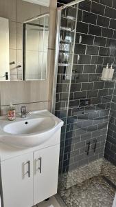 a bathroom with a sink and a shower with a mirror at KADESE Holiday North Beach Durban in Durban