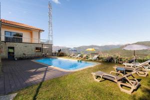 a villa with a swimming pool and lawn chairs at Casa de Balinhas - Gerês in Cova
