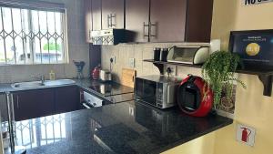 a kitchen with a counter top with a microwave at KADESE Holiday North Beach Durban in Durban