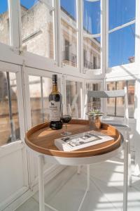 a table with a bottle of wine and a glass at Apartamento Duplex casa Palacio rehabilitado centro El Puerto in El Puerto de Santa María