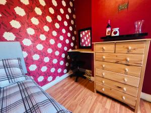 盧頓的住宿－Cozy One bedroom house with garden in Luton，一间卧室设有梳妆台和红色的墙壁