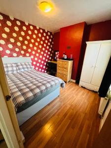 a bedroom with a bed with a polka dot wall at Cozy One bedroom house with garden in Luton in Luton