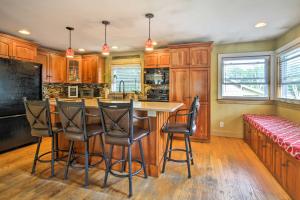 a kitchen with wooden cabinets and a bar with stools at Large Maine Home - 5 Min Walk to Old Orchard Beach in Old Orchard Beach