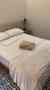 a white bed with a towel on top of it at Casarão 47 in Areia