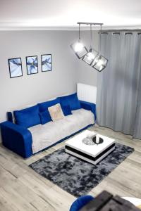 un soggiorno con divano blu e tavolo di Apartament Nowe Redzikowo 2 