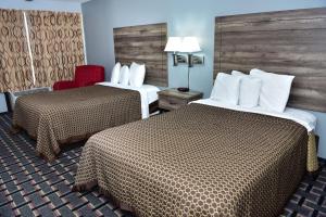 a hotel room with two beds and a red chair at Americas Best Value Inn Douglasville in Douglasville +21 photos