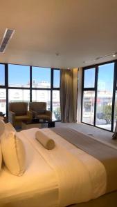 فندق البيت الابيض للاجنحه الفندقيه في خميس مشيط: سرير أبيض كبير في غرفة مع نوافذ كبيرة