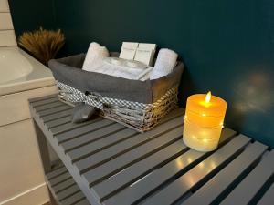 a candle and a basket with towels and a basket with a candle gmaxwell gmaxwell gmaxwell at Stonehenge Cottages in Salisbury