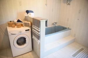 a bathroom with a washing machine and a bath tub at Villa Claudia Lemon Appartment in Premantura