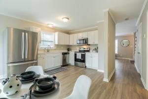 夏洛特的住宿－Modern Stunning SouthPark/Cotswold Home!，厨房配有白色橱柜和桌椅