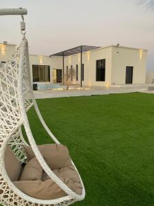 a white hammock in a yard with a building at Seagemfuj in Fujairah