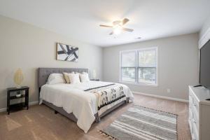 a white bedroom with a bed and a ceiling fan at Modern Stunning SouthPark/Cotswold Home! in Charlotte