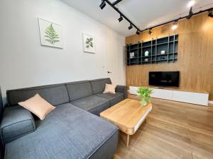 a living room with a couch and a coffee table at Garnizon by Q4Apartments in Gdańsk