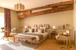 a bedroom with a bed and a table and chairs at H&ocirc;tel Chais Monnet & Spa in Cognac
