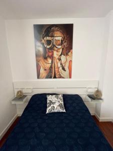 a bedroom with a painting of a woman wearing a gas mask at Apartamento Fatima in Santa Cruz de la Palma