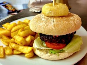 um hambúrguer e batatas fritas num prato branco em The Sportsmans Inn Limited em Ivybridge